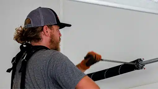 Technician performing repairs on a garage door